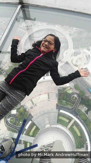 A brave guest on a glass-bottomed sightseeing floor at 259 meters