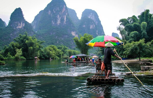 Naturaleza en China: paseo en balsa de bambú por un río rodeado de montañas