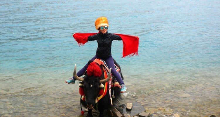 Riding a yak by the lake
