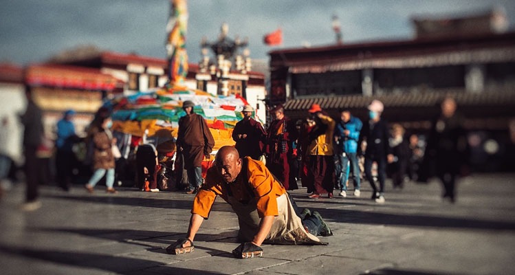 Tibetans prostrate themselves on the ground