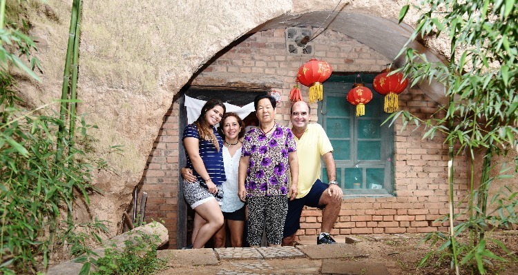 people in front of a cave dwelling