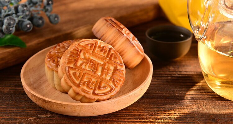 Mooncakes, tea, and blueberries were laid out on the wooden table to celebrate the traditional Chinese Mid-Autumn Festival.