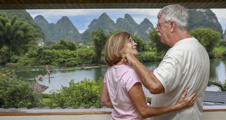 An elder couple are relaxing with karst landscape in a Yangshuo hotel