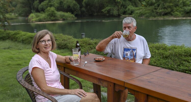 An elderly couple sat having afternoon tea by the Yulong River in Yangshuo's Shili Gallery.