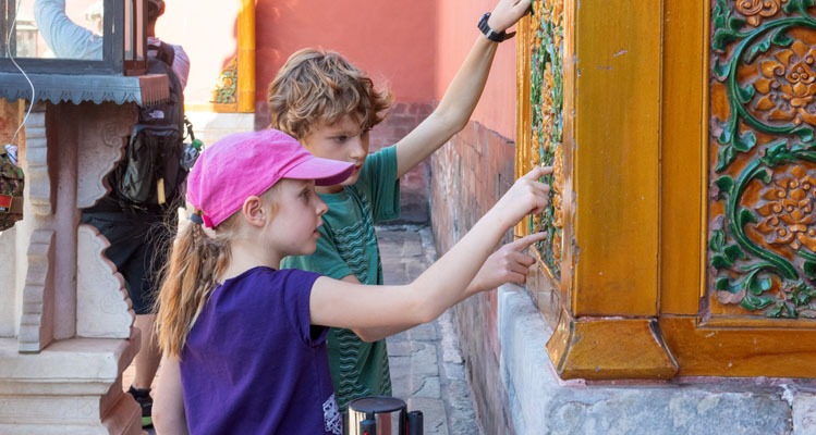 children touching the yellow and green tiles on the wall