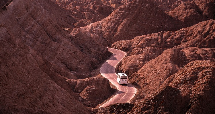 a bus on the road in the red mountains