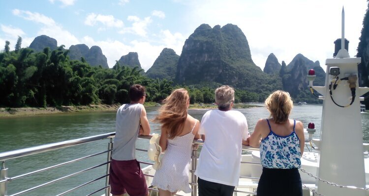 Four tourists leaned on the railing of the cruise ship to admire the Guilin landscape