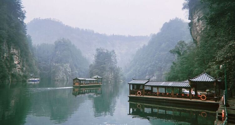 On the tranquil Baofeng Lake, shrouded in a thin winter mist, a tourist boat rests quietly at the shore.