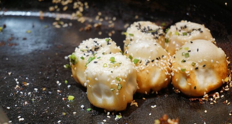 Shengjianbao con una generosa capa de sésamo
