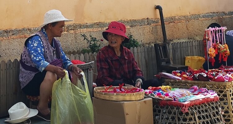 Bai people are selling goods along the wall