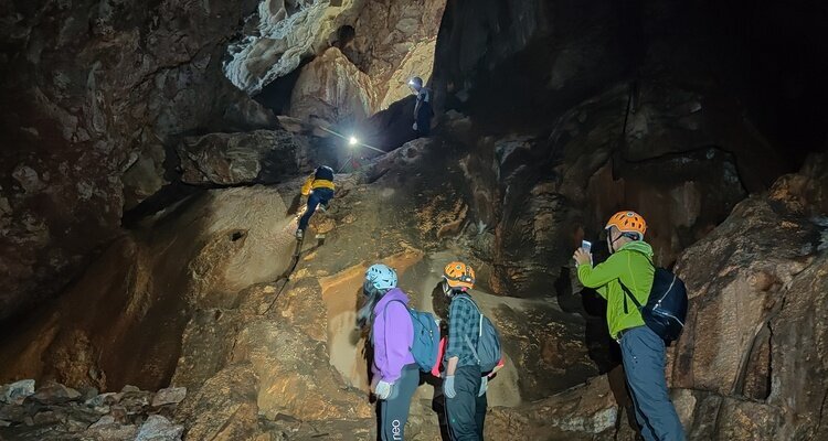 A couple of people are caving into a pristine karst cave