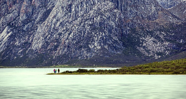 the people standing on the bank of the lake