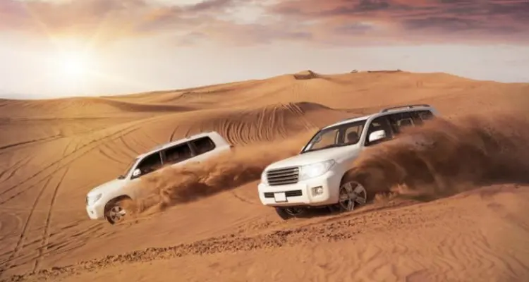 two cars driving in the desert in Zhongwei