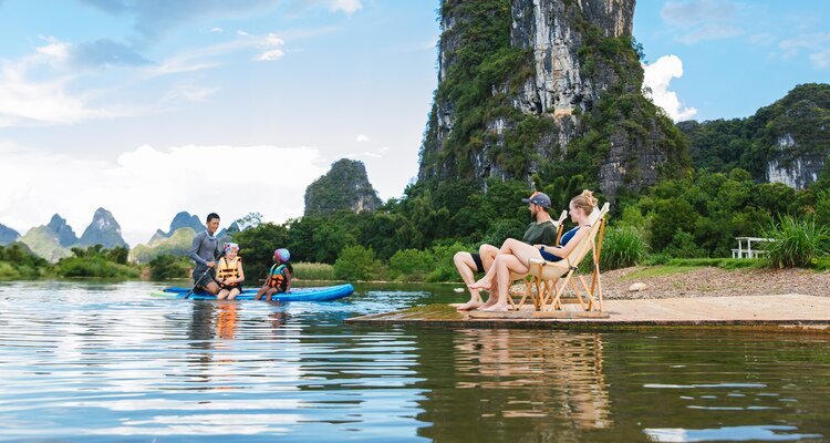 Famiglia in viaggio a Yangshuo tra fiume e paesaggi carsici durante un tour in Cina