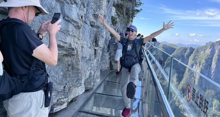 A lovely couple enjoys the sunshine on the glass skywalk at Tianmen Mountain.
