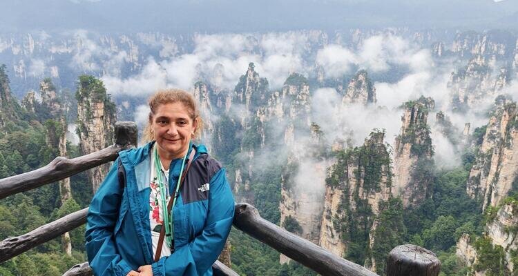 One of our middle-aged white female guests took a photo with her back to the misty Tianzi Mountain.