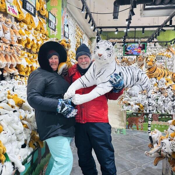 Un cliente abraza un adorable peluche de tigre siberiano